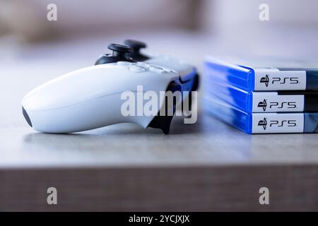 Brecht, Belgio - 3 ottobre 2024: Ritratto di un controller PlayStation 5 accanto alle custodie di gioco con il logo ps5. tutto è pronto Foto Stock