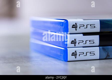 Brecht, Belgio - 3 ottobre 2024: Un ritratto laterale di 3 custodie di giochi per PlayStation 5 o PS5 sovrapposte, pronte per essere aperte e giocate con spirito Foto Stock