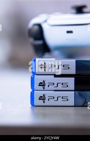 Brecht, Belgio - 3 ottobre 2024: Primo piano verticale di un controller PlayStation 5 sopra le custodie di gioco con il logo ps5. tutto lo è Foto Stock