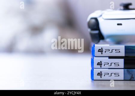 Brecht, Belgio - 3 ottobre 2024: Un ritratto di un controller PlayStation 5 adagiato sopra le custodie di gioco con il logo ps5. tutto è pronto Foto Stock