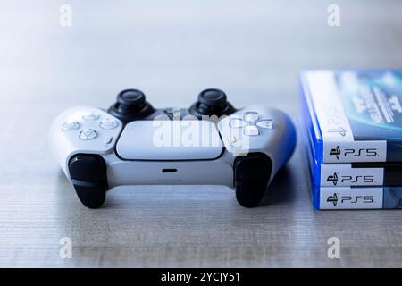 Brecht, Belgio - 3 ottobre 2024: Un controller per PlayStation 5 davanti alle custodie dei giochi con il logo ps5. e' tutto pronto per fare un vid Foto Stock