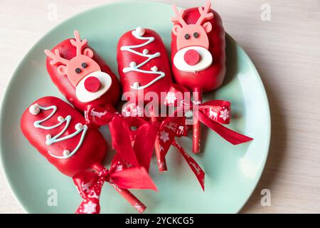 Stesa piatta di torta pop gelato su un bastoncino in glassa rosa con fragole e mirtilli su uno sfondo chiaro. Foto Stock