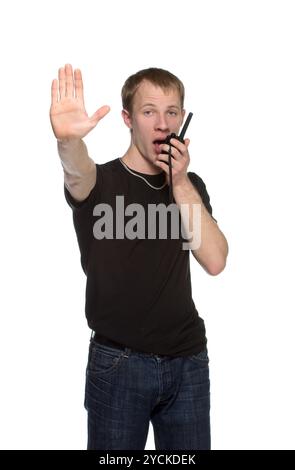 Un giovane agente di sicurezza che parla attraverso il suo walkie talkie. Foto Stock