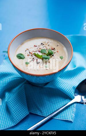 Zuppa spessa nel recipiente su un tovagliolo blu e fondo Foto Stock