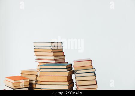 Pile di libri per insegnare in biblioteca su sfondo bianco Foto Stock