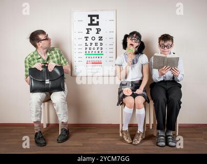 Tre persone che indossano gli occhiali in un ufficio del medico Foto Stock