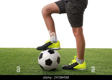 Giocatore di calcio con palla su erba artificiale su sfondo bianco, primo piano Foto Stock