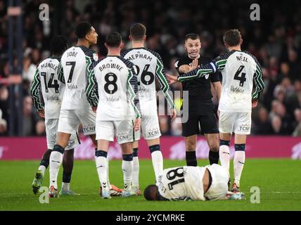 L'arbitro Tom Nield è circondato dai giocatori dei Sunderland dopo un fallo su Wilson Isidor (Bottom) di Sunderland durante il match per il titolo Sky Bet a Kenilworth Road, Luton. Data foto: Mercoledì 23 ottobre 2024. Foto Stock