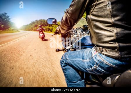 Bikers alla guida di un motociclo lungo la strada asfaltata (movimento sfocata). Visuale in prima persona. Focus sul cruscotto di un motociclo Foto Stock