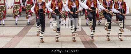 Ballerini in vivaci costumi che eseguono danze tradizionali popolari all'aperto Foto Stock