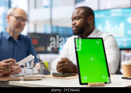 Il consulente finanziario assiste le vecchie coppie a scegliere un piano di pensionamento e a garantire il loro reddito, avendo un tablet con chiave cromatica. Broker che parla con gli anziani dei risparmi di vita. Foto Stock