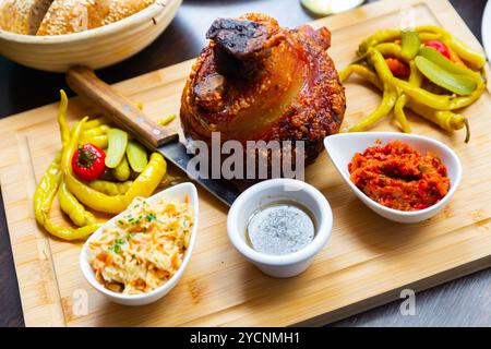 Schweinsstelze su tavola in legno Foto Stock