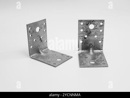 angoli metallici per i dispositivi di fissaggio su sfondo bianco. Foto Stock