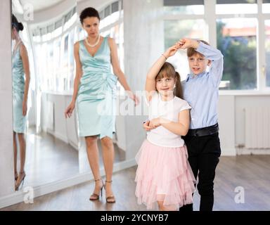 Ballerini Tween, ragazza e ragazzo che praticano il valzer in uno studio di danza Foto Stock