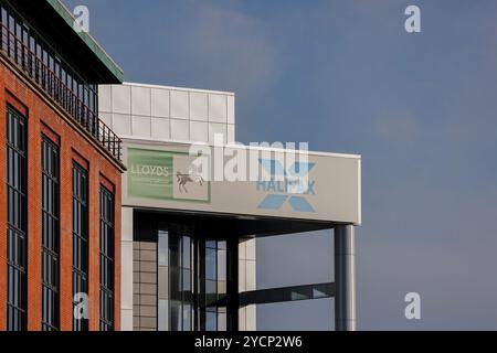 L'ufficio della banca firma il cielo blu. L'insegna Halifax Banking Group accanto all'insegna Halifax sull'esterno dell'edificio. Foto Stock