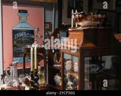 Oggetti d'antiquariato in mostra oggetti d'antiquariato in vendita, visti attraverso la vetrina del negozio d'antiquariato. Foto Stock
