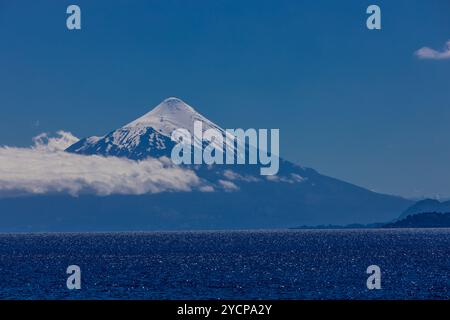 Vulcano Osorno in Cile. L'anello del fuoco cratere vulcanico e lava sulle pendici di un'alta montagna. Rocce rosse vulcaniche e picco innevato Foto Stock