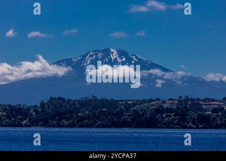 Vulcano Osorno in Cile. L'anello del fuoco cratere vulcanico e lava sulle pendici di un'alta montagna. Rocce rosse vulcaniche e picco innevato Foto Stock