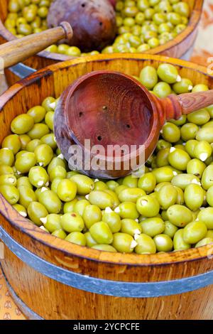 Olive verdi in secchio di legno venduto sul mercato Foto Stock