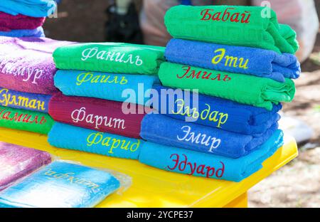 Pila di multi asciugamani colorati con nomi in lingua tartara Foto Stock