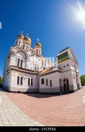 Chiesa russa ortodossa con cupole d'oro contro la luce diretta del sole Foto Stock