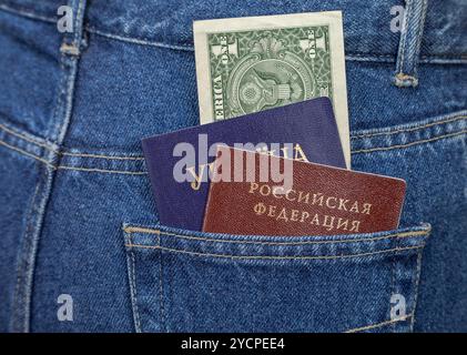 Passaporti ucraini e russi nella tasca posteriore dei jeans Foto Stock