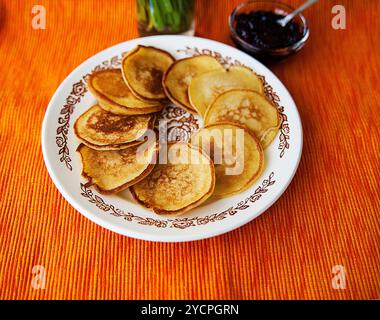 Frittelle calde con confettura di fragole sul tovagliolo Foto Stock