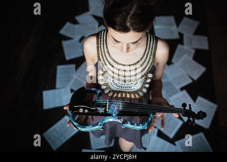 Ragazza che posa e tiene in mano un violino Foto Stock