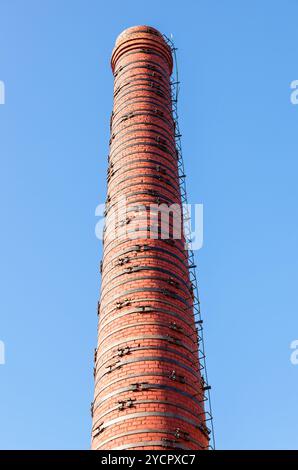 Vecchio rosso mattone camino contro il cielo blu Foto Stock