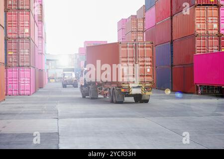 Un deposito di container e carrelli elevatori funzionano sotto un cielo parzialmente nuvoloso. Foto Stock