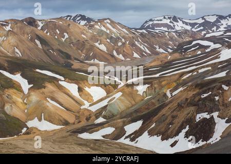 Montagne colorate di riolite con residui di neve al vulcano Blahnukur a Landmannalaugar, Parco Nazionale Fjallabak, Sudurland, Islanda Foto Stock