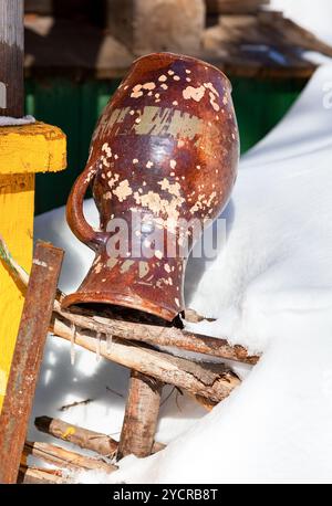 Vecchia Caraffa in ceramica appesa alla recinzione in inverno Foto Stock