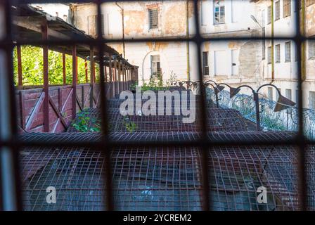 Vista attraverso i bar del cortile della prigione Foto Stock