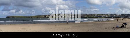 Kilkee, Irlanda, 4 agosto 2022: Le persone godono di una calda giornata estiva sulla spiaggia di sabbia dorata di Kilkee nell'Irlanda occidentale, in Europa Foto Stock