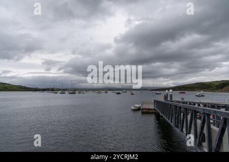 Clew Bay, Irlanda, 23 luglio 2022: Molo e molo Rosmoney con molte barche a vela e yacht ancorati nelle acque di Clew Bay sotto un cielo coperto, Foto Stock