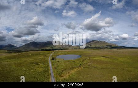 La stretta strada di campagna conduce nel paesaggio selvaggio del Connemara National Park, nell'Irlanda occidentale Foto Stock