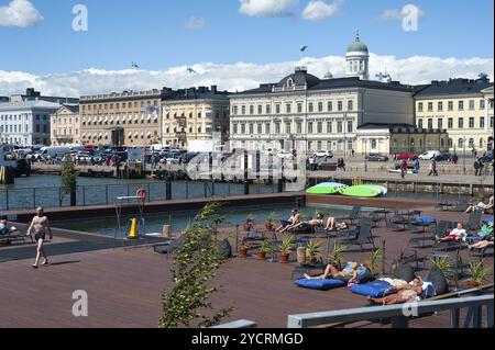 23.06.2018, Helsinki, Finlandia, Europa, i visitatori prendono il sole sulla terrazza solarium della piscina Allas Sea con vista del porto e della piazza del mercato. Poll Foto Stock