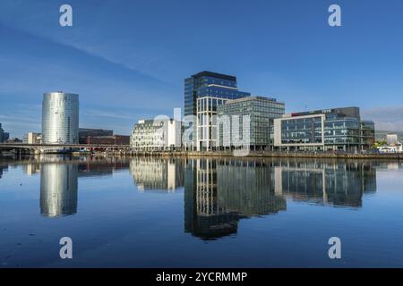Belfast, Regno Unito, 21 agosto 2022: Skyline del centro di Belfast con grattacieli e riflessi nel tranquillo fiume Lagan all'alba, in Europa Foto Stock