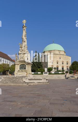 PECS, Ungheria, 13 ottobre, 2022: Veduta della Statua della Santissima Trinità e della Moschea di Pasha Qasim in Piazza Szechenyi nel centro di Pecs, Europa Foto Stock