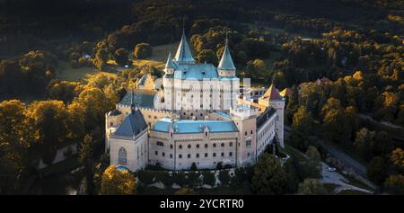 Bojnice, Slovacchia, 26 settembre 2022: Vista panoramica aerea del castello di Bojnice in Slovacchia circondata dalla foresta nella calda luce serale, Europa Foto Stock