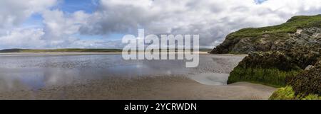 Panorama della spiaggia di sabbia dorata di Maghera con rocce ricoperte di alghe e scogliere in primo piano Foto Stock
