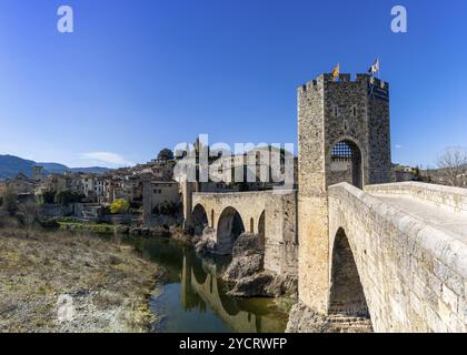 Besalu, Spagna, 1 marzo 2023: Veduta del ponte romanico medievale e del villaggio di Besalu in Catalogna, Europa Foto Stock