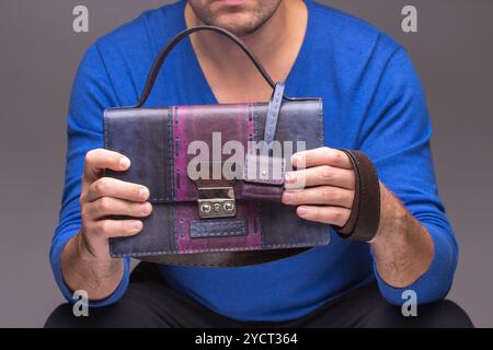 Mani maschili forti che tengono le borse Foto Stock