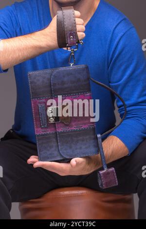 Mani maschili forti che tengono le borse Foto Stock
