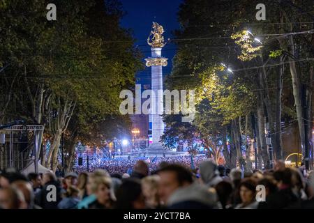Tbilisi, Georgia. 23 ottobre 2024. I sostenitori di Georgian Dream si trovano lungo Rustaveli Avenue, di fronte al palcoscenico per i discorsi pre-elettorali, con il Freedom Monument visibile in lontananza. L'evento segna un momento critico nel calendario politico del paese. Catturato mercoledì 23 ottobre 2024. (VX Photo/ Vudi Xhymshiti) crediti: VX Pictures/Alamy Live News Foto Stock