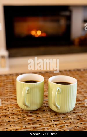 Natale, serata accogliente, due tazze da caffè sul tavolo accanto al caminetto caldo, a casa Foto Stock