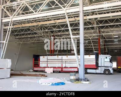 Un carrello parcheggiato all'interno di un cantiere, che consegna materiali per un progetto industriale. Foto Stock