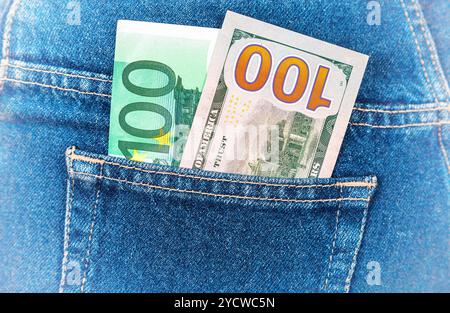 Banconote da cento euro e un centinaio di dollari americani fuori della schiena tasca dei jeans Foto Stock