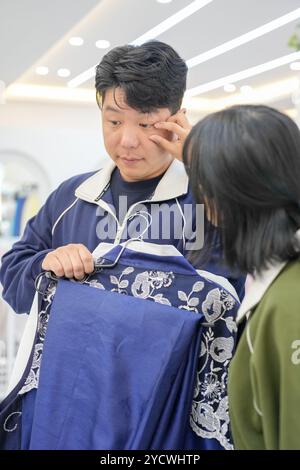 Una coppia coreana, un uomo di 30 anni e una donna di 20 anni, scelgono armoniosamente i vestiti da indossare in un negozio di noleggio di hanbok a Seoul, Corea del Sud. Foto Stock