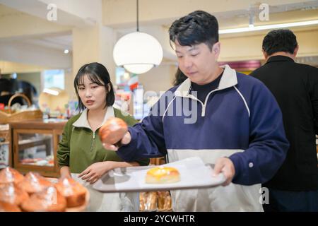 Una coppia, un uomo coreano di 30 anni e una donna di 20 anni, indossa tute e goditi un pomeriggio in un bel caffè in stile occidentale a Seoul, Corea del Sud. Foto Stock
